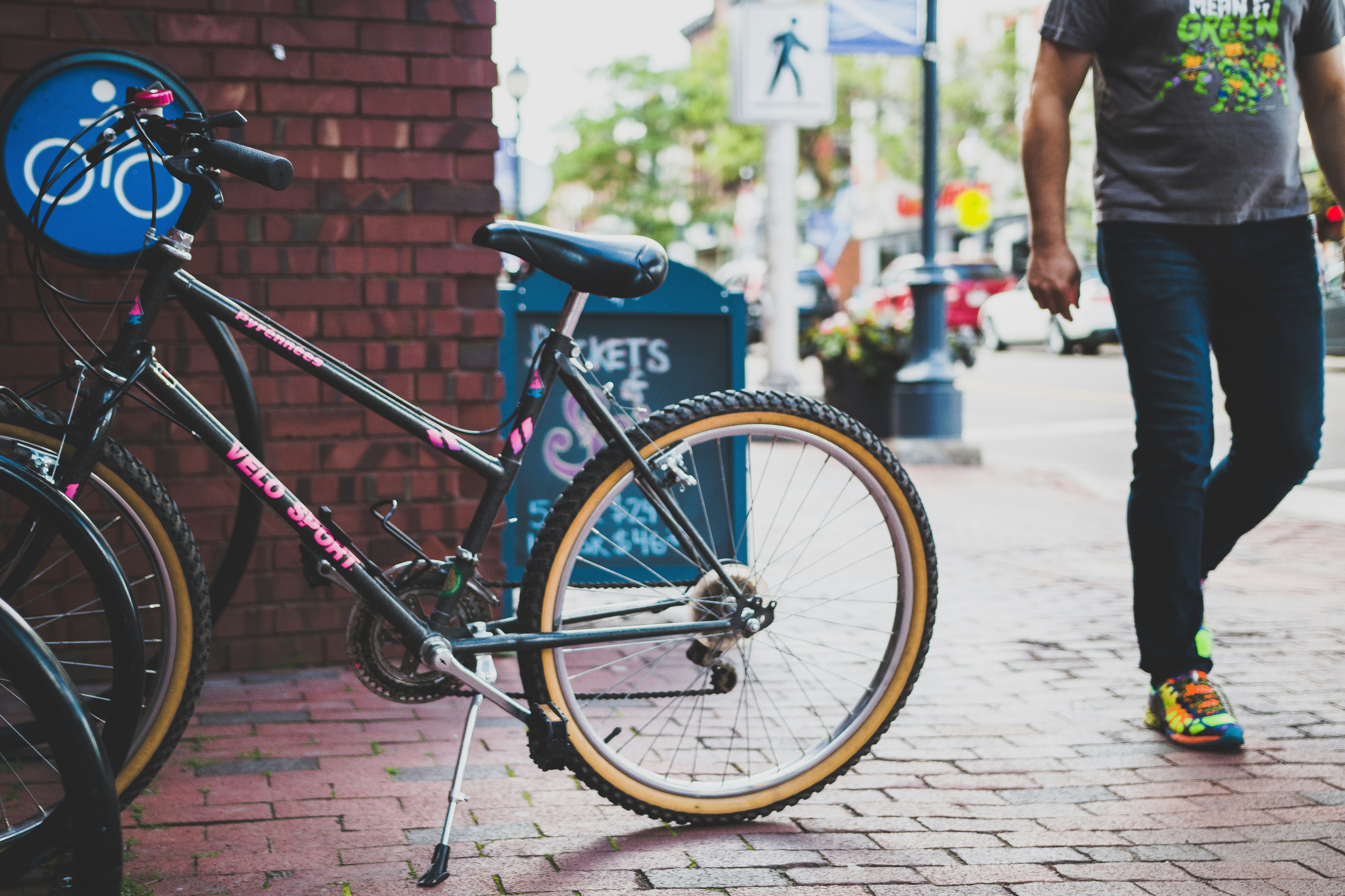 black bicycle parked beside brick wall